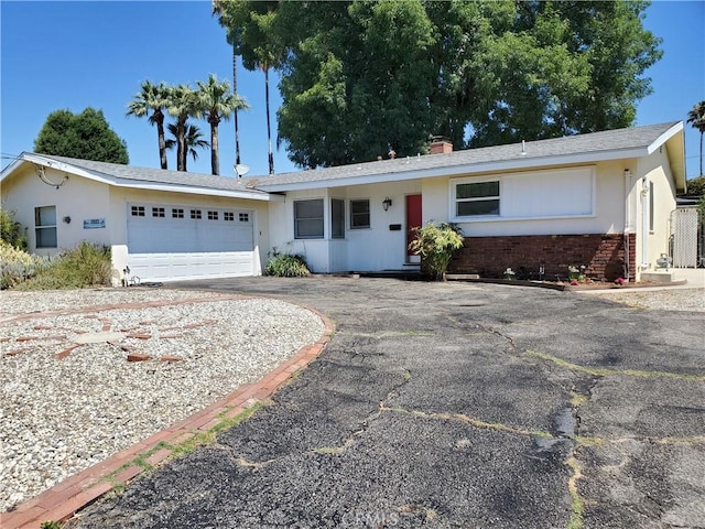 17623 Clymer St, Granada Hills, CA 91344 - ranch-style home with driveway, an attached garage, stucco siding, and brick siding