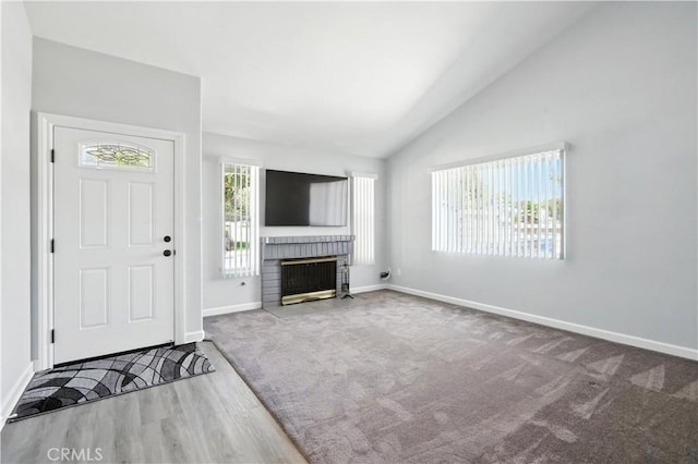 25796 Olivas Park Rd, Valencia, CA 91355 - unfurnished living room featuring a brick fireplace, wood finished floors, carpet flooring, and high vaulted ceiling