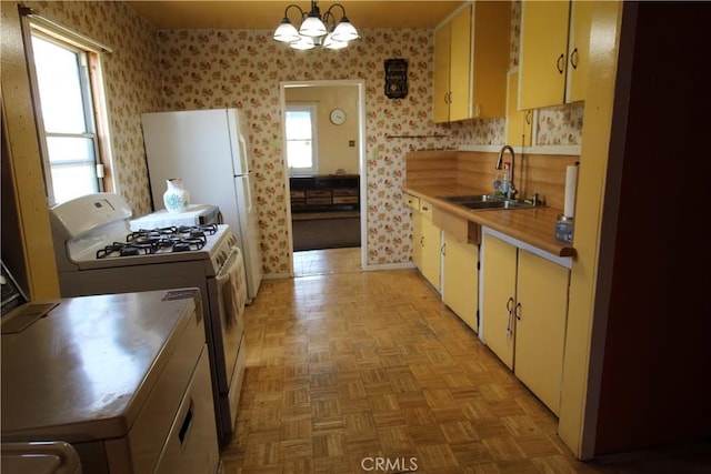 20512 Berendo Ave, Torrance, CA 90502 - kitchen featuring white gas range, plenty of natural light, wallpapered walls, stainless steel countertops, and a chandelier