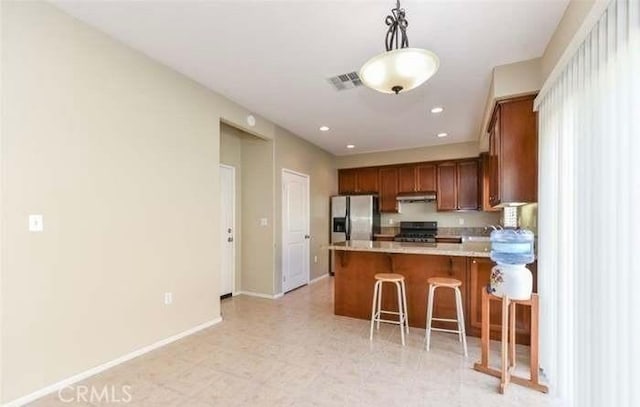 1063 S Reservoir St, Pomona, CA 91766 - kitchen with range, under cabinet range hood, stainless steel fridge, light countertops, and a peninsula
