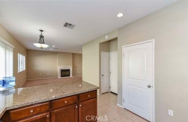 1063 S Reservoir St, Pomona, CA 91766 - kitchen featuring light stone counters, hanging light fixtures, a fireplace, light tile patterned flooring, and recessed lighting