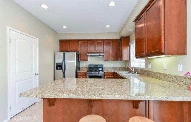 1063 S Reservoir St, Pomona, CA 91766 - kitchen with stainless steel appliances, a peninsula, light stone counters, light tile patterned floors, and recessed lighting