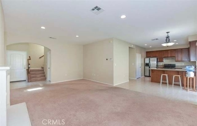 1063 S Reservoir St, Pomona, CA 91766 - unfurnished living room with arched walkways, light colored carpet, recessed lighting, and stairway