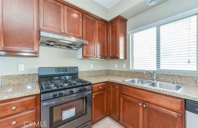 1063 S Reservoir St, Pomona, CA 91766 - kitchen featuring appliances with stainless steel finishes, under cabinet range hood, healthy amount of natural light, and brown cabinetry