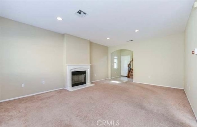 1063 S Reservoir St, Pomona, CA 91766 - unfurnished living room featuring arched walkways, carpet flooring, a fireplace with raised hearth, and recessed lighting