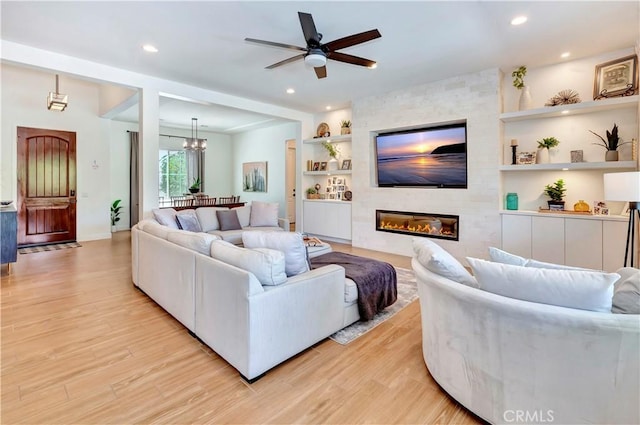 48692 Pear St, Indio, CA 92201 - living area featuring built in shelves, light wood-type flooring, a ceiling fan, a fireplace, and a chandelier