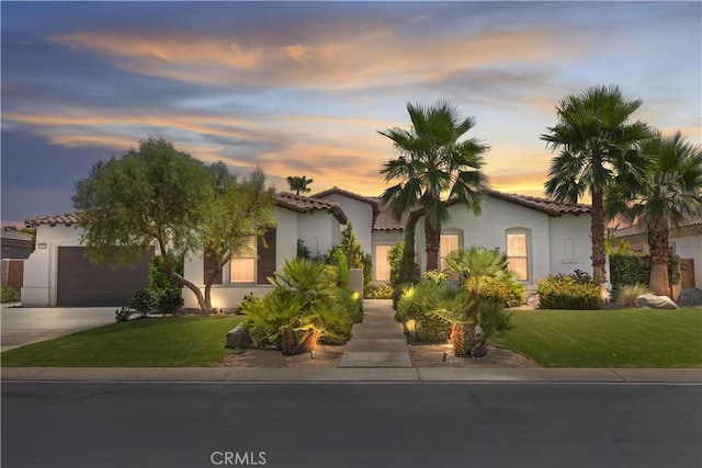 48692 Pear St, Indio, CA 92201 - mediterranean / spanish-style home with stucco siding, a tiled roof, an attached garage, concrete driveway, and a front lawn