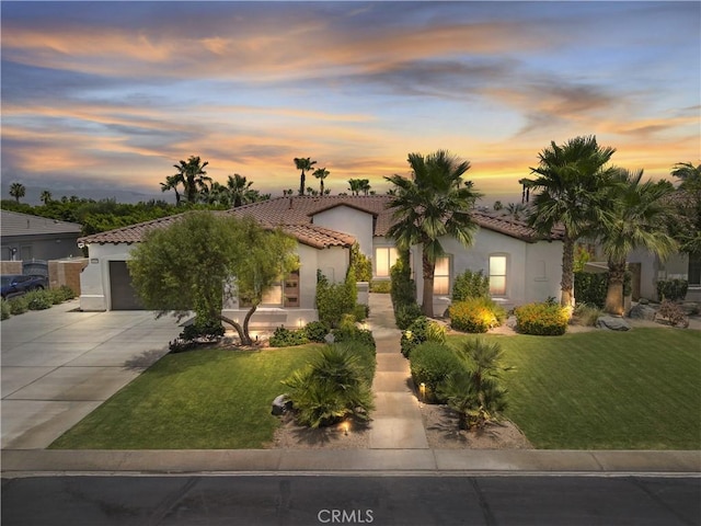 48692 Pear St, Indio, CA 92201 - mediterranean / spanish house with stucco siding, a tiled roof, driveway, and a yard