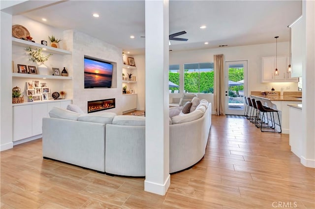 48692 Pear St, Indio, CA 92201 - living area featuring ceiling fan, light wood finished floors, a fireplace, built in features, and recessed lighting