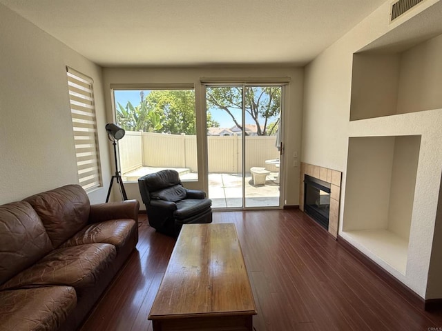 1111 Magellan Way, Chula Vista, CA 91910 - living room with dark wood-type flooring, a tiled fireplace, and a textured wall