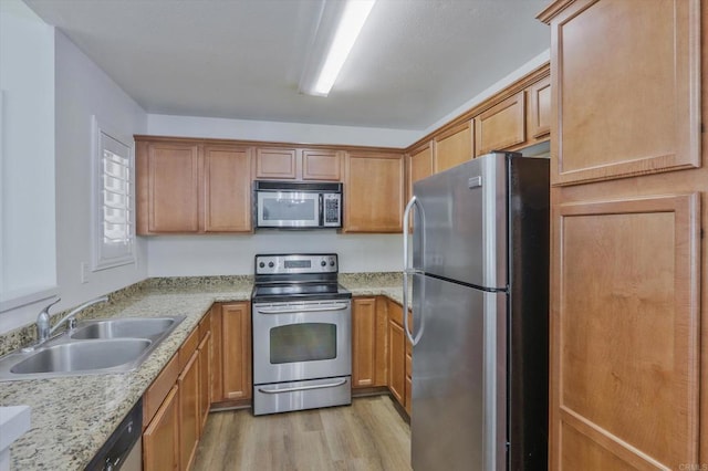 12191 Cuyamaca College Dr E Unit 210, El Cajon, CA 92019 - kitchen featuring stainless steel appliances, light wood-style flooring, brown cabinets, and light stone countertops