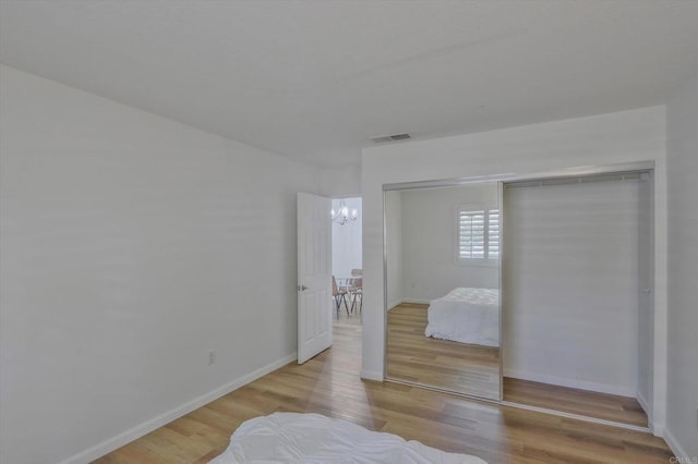 12191 Cuyamaca College Dr E Unit 210, El Cajon, CA 92019 - bedroom with wood finished floors, a chandelier, and a closet