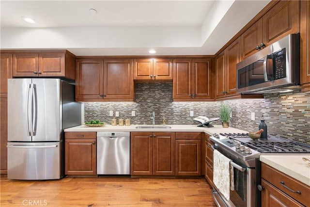 627 Deep Valley Dr Unit 410, Rolling Hills Estates, CA 90274 - kitchen with appliances with stainless steel finishes, light countertops, light wood-style floors, backsplash, and brown cabinets