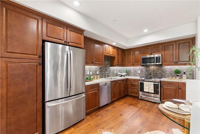 627 Deep Valley Dr Unit 410, Rolling Hills Estates, CA 90274 - kitchen featuring stainless steel appliances, light wood-type flooring, light countertops, backsplash, and brown cabinetry