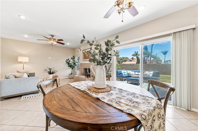 18202 Foss Ln, Huntington Beach, CA 92648 - dining space featuring ceiling fan, light tile patterned floors, recessed lighting, and a fireplace with raised hearth