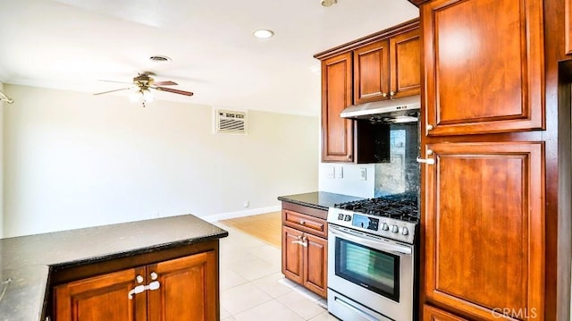 7360 Thunderbird Ln, Stanton, CA 90680 - kitchen featuring stainless steel gas range, under cabinet range hood, dark countertops, a ceiling fan, and recessed lighting