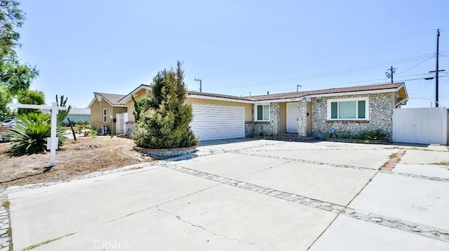 7360 Thunderbird Ln, Stanton, CA 90680 - view of front of home with a garage, stone siding, and concrete driveway