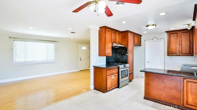 7360 Thunderbird Ln, Stanton, CA 90680 - kitchen featuring stainless steel range with gas cooktop, ceiling fan, dark stone countertops, tasteful backsplash, and under cabinet range hood