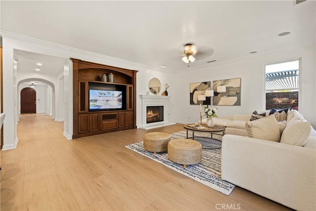20100 Livorno Ln, Yorba Linda, CA 92886 - living area with a ceiling fan, arched walkways, light wood finished floors, crown molding, and a warm lit fireplace