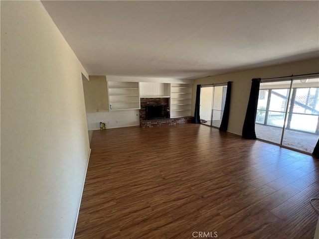 43216 San Miguel Way, Hemet, CA 92544 - unfurnished living room featuring dark wood finished floors, a fireplace, and built in features