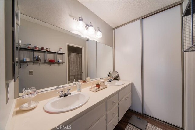 2614 S Quarry Ln Unit D, Walnut, CA 91789 - full bathroom featuring double vanity, a textured ceiling, and wood finished floors