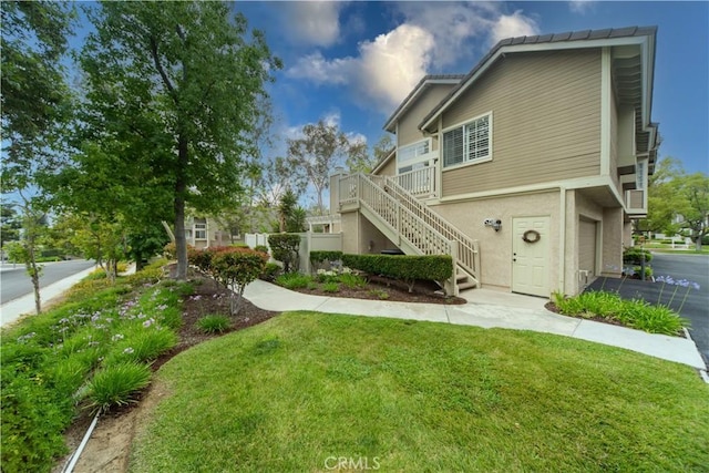 2614 S Quarry Ln Unit D, Walnut, CA 91789 - townhome / multi-family property with stairway, a front lawn, an attached garage, and stucco siding