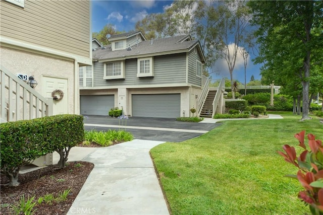 2614 S Quarry Ln Unit D, Walnut, CA 91789 - view of front of property with stairs, driveway, a front yard, an attached garage, and stucco siding