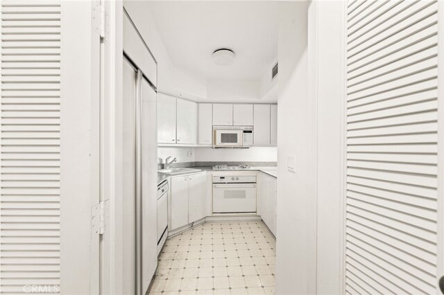 500 W Harbor Dr Unit 808, San Diego, CA 92101 - kitchen with white appliances, white cabinets, light countertops, and a raised ceiling