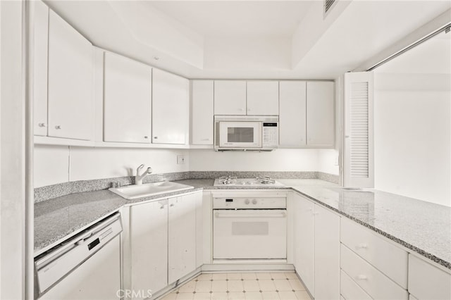 500 W Harbor Dr Unit 808, San Diego, CA 92101 - kitchen featuring white appliances, white cabinetry, light flooring, and light stone counters