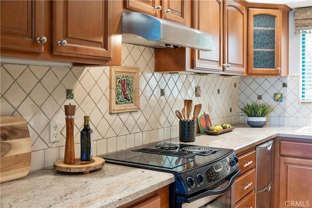 201 Calle Miramar Unit 8, Redondo Beach, CA 90277 - kitchen featuring black range with electric stovetop, under cabinet range hood, decorative backsplash, and glass insert cabinets