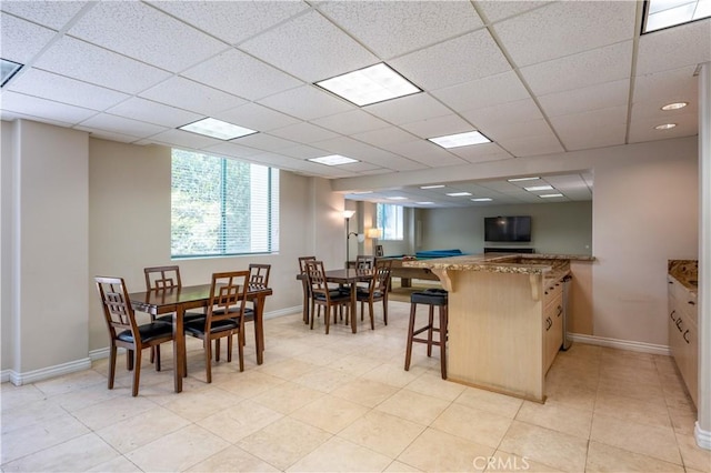 201 Calle Miramar Unit 8, Redondo Beach, CA 90277 - kitchen featuring a breakfast bar, a peninsula, stone countertops, and a paneled ceiling