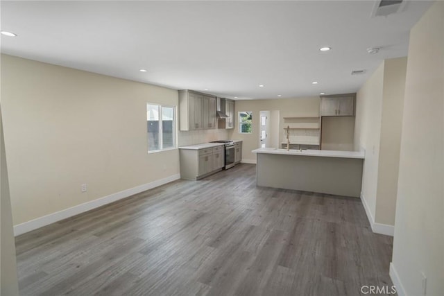 3123 Hyde Park Blvd, Los Angeles, CA 90043 - kitchen with stainless steel gas stove, gray cabinets, recessed lighting, wood finished floors, and light countertops