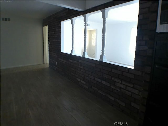 9831 Tangelo Ave, Bloomington, CA 92316 - empty room featuring brick wall and wood finished floors
