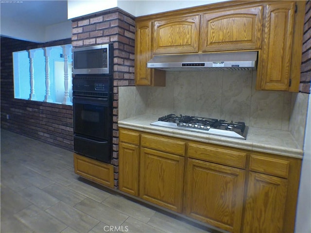 9831 Tangelo Ave, Bloomington, CA 92316 - kitchen featuring stainless steel appliances, under cabinet range hood, a warming drawer, and brown cabinets