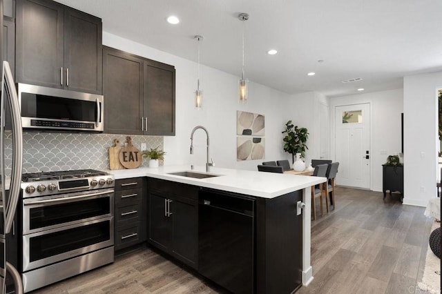 3141 Dega Pl, Carlsbad, CA 92010 - kitchen featuring stainless steel appliances, a peninsula, tasteful backsplash, light wood finished floors, and light countertops
