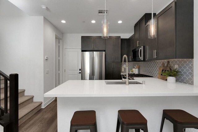 3141 Dega Pl, Carlsbad, CA 92010 - kitchen featuring appliances with stainless steel finishes, a peninsula, dark wood finished floors, light countertops, and recessed lighting