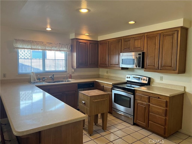 296 E 19th St, Costa Mesa, CA 92627 - kitchen featuring appliances with stainless steel finishes, a peninsula, light countertops, and recessed lighting