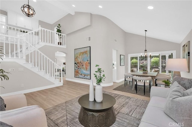 21212 Valleyview Dr, Walnut, CA 91789 - living room with a chandelier, stairs, light wood-style flooring, high vaulted ceiling, and arched walkways