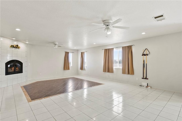 8379 Beaver Ave, Phelan, CA 92371 - unfurnished living room featuring ceiling fan, tile patterned flooring, a tile fireplace, recessed lighting, and a textured ceiling