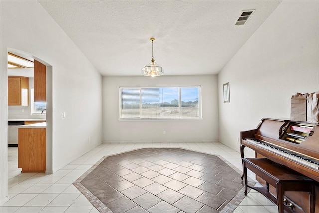 8379 Beaver Ave, Phelan, CA 92371 - dining area with light tile patterned floors, arched walkways, a chandelier, and a textured ceiling