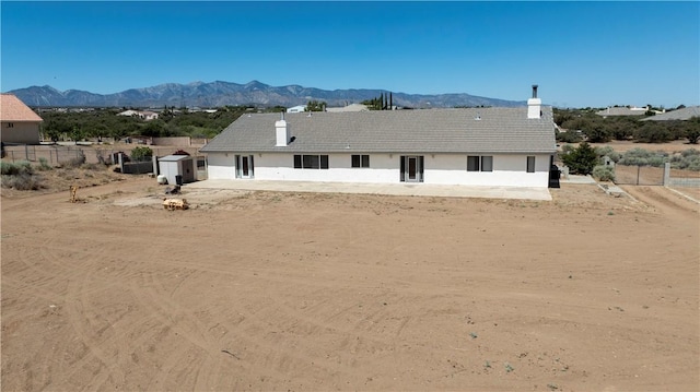 8379 Beaver Ave, Phelan, CA 92371 - view of front facade with a storage shed, a mountain view, a chimney, and stucco siding