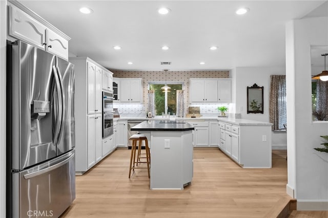 42333 Casa Verde, Temecula, CA 92592 - kitchen featuring appliances with stainless steel finishes, a breakfast bar area, light wood-style flooring, white cabinets, and decorative backsplash