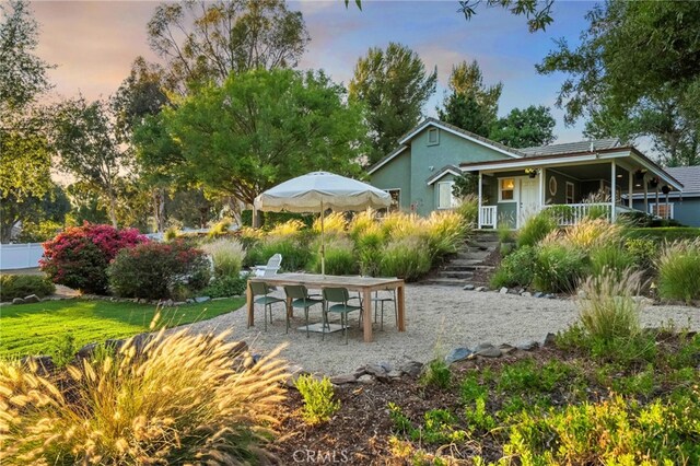 42333 Casa Verde, Temecula, CA 92592 - back of property at dusk with stucco siding, a porch, and outdoor dining space