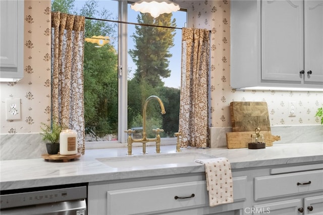 42333 Casa Verde, Temecula, CA 92592 - kitchen with wallpapered walls, dishwasher, light stone counters, and white cabinetry