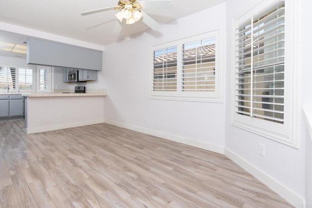 28328 Via Bandita, Menifee, CA 92585 - kitchen with stainless steel microwave, gray cabinets, light wood finished floors, and ceiling fan