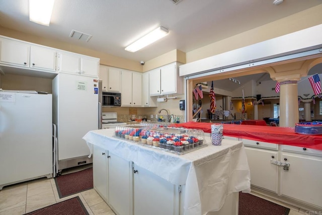 28328 Via Bandita, Menifee, CA 92585 - kitchen with freestanding refrigerator, black microwave, white cabinetry, and light countertops