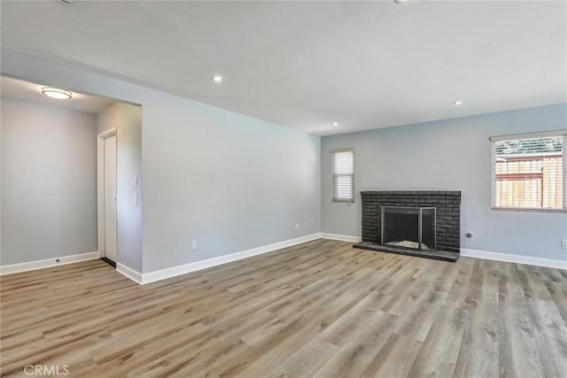 3810 Adams St, Lake Elsinore, CA 92530 - unfurnished living room featuring light wood-type flooring, a brick fireplace, and recessed lighting