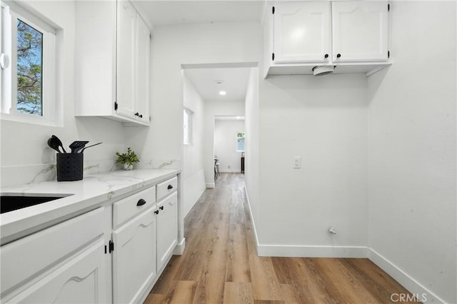 14581460 W 80th St, Los Angeles, CA 90047 - kitchen with white cabinetry, light wood finished floors, and light stone countertops