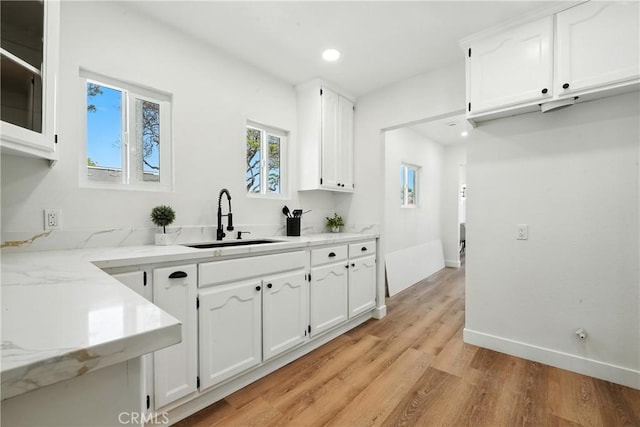 14581460 W 80th St, Los Angeles, CA 90047 - kitchen featuring white cabinetry, light wood-style floors, light stone counters, recessed lighting, and glass insert cabinets