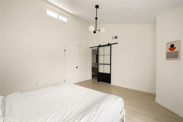680 E Workman St, Covina, CA 91723 - bedroom with a barn door, light wood-style floors, and lofted ceiling